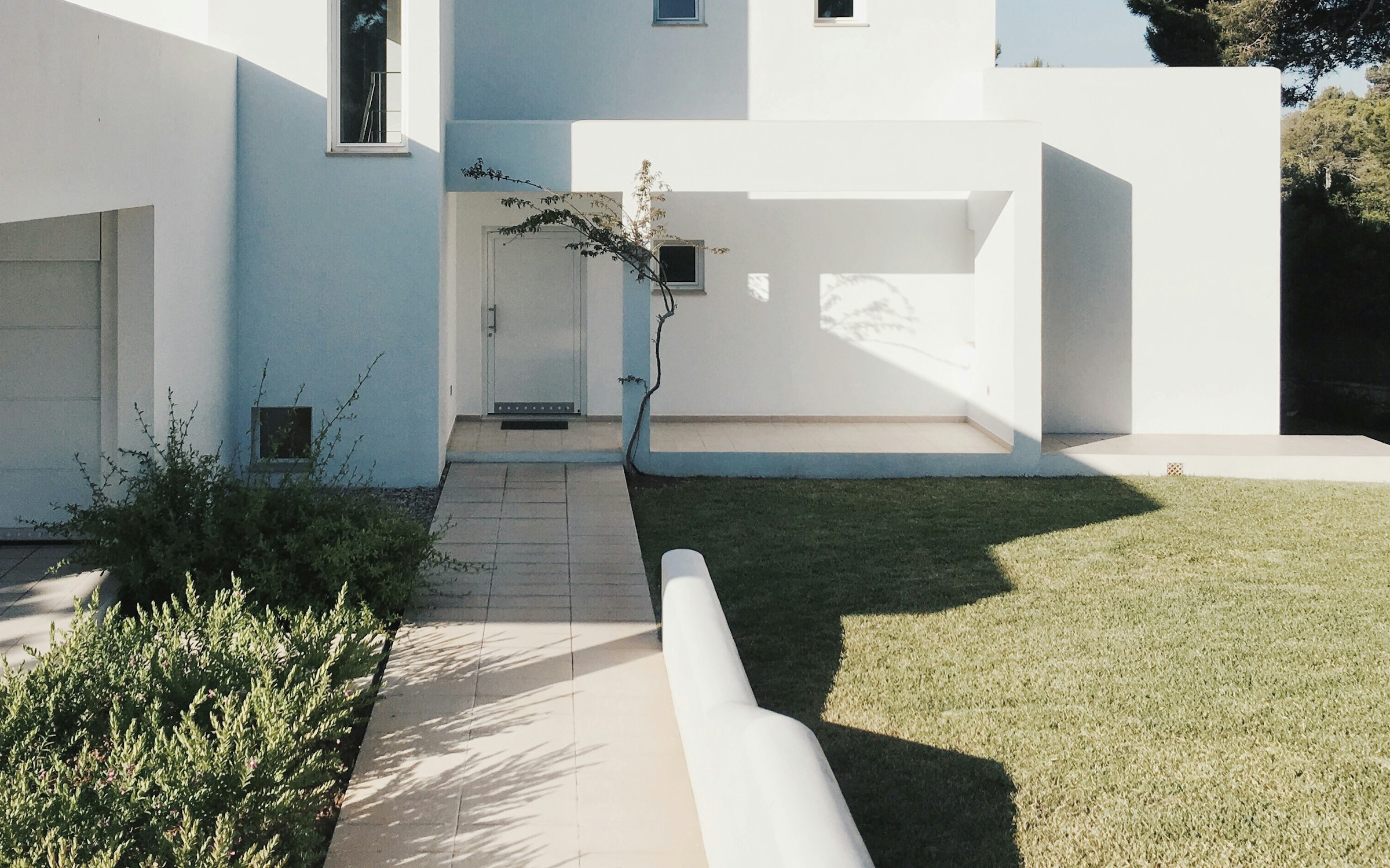 Minimalist institutional building with a landscaped entrance path and lawn.