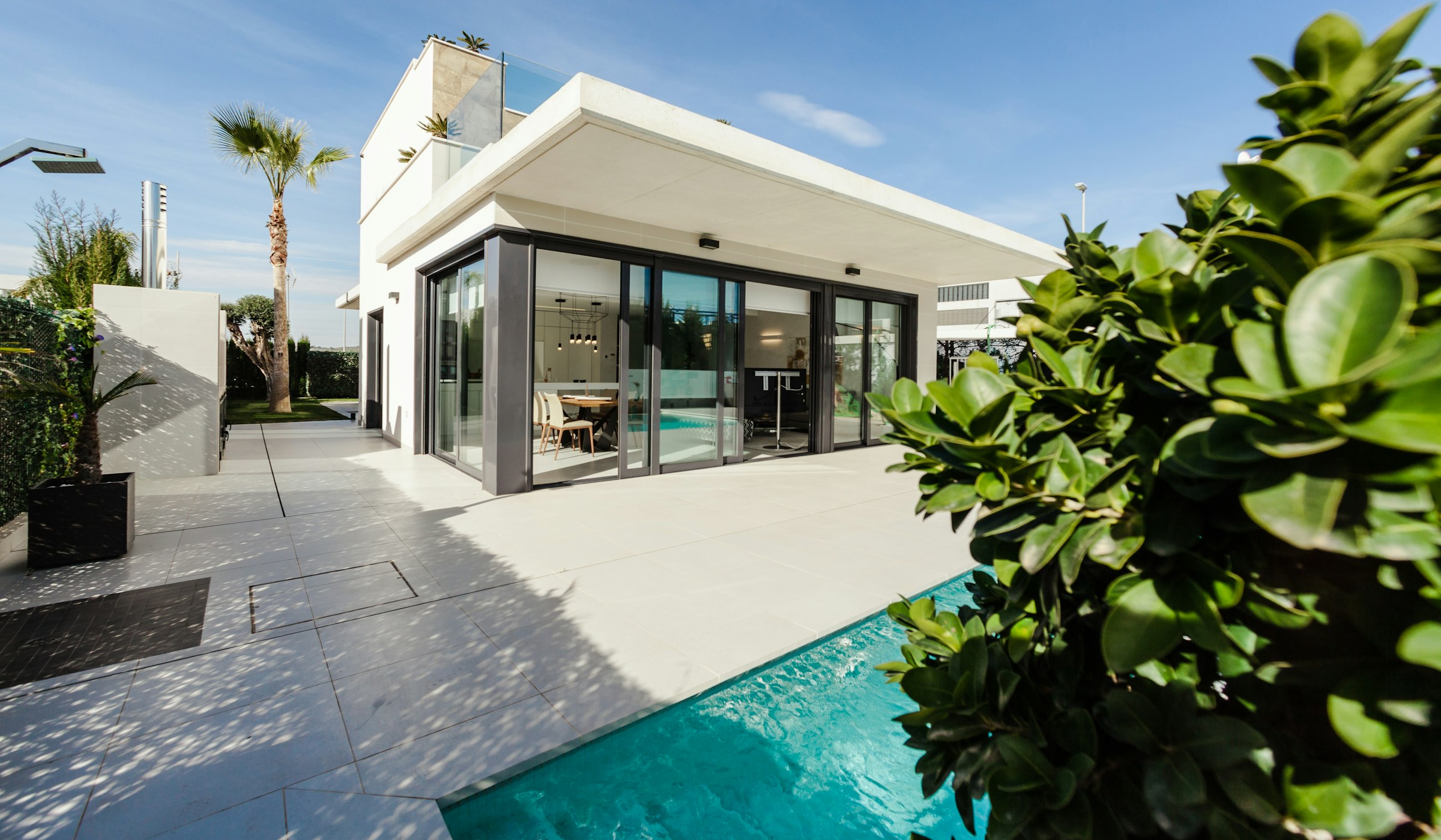Modern residence with pool terrace, photographed in natural daylight.