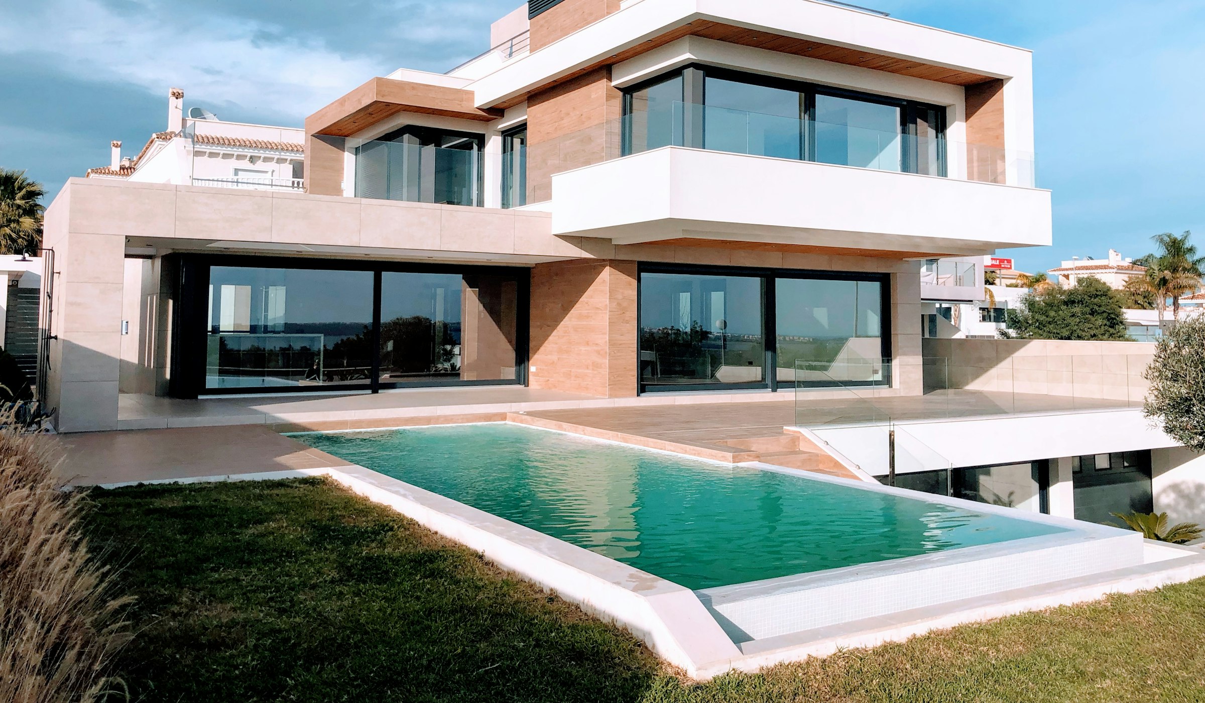 Modern architecture with a landscaped terrace and pool overlooking the coastline.